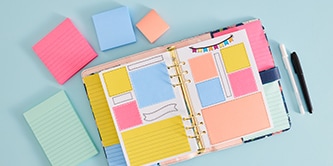 Un planner aperto con Foglietti Post-it&reg; colorati, circondato da Foglietti Post-it&reg; di varie dimensioni nei colori rosa, blu e pesca
