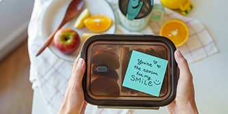 Una scatola per il pranzo con un messaggio sentito su un Foglietto Post-it&reg; che dice: "Sei la ragione del mio sorriso"
