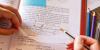 Uno studente che annota un libro di testo con un Foglietto Post-it&reg; trasparente, evidenziando le equazioni matematiche
